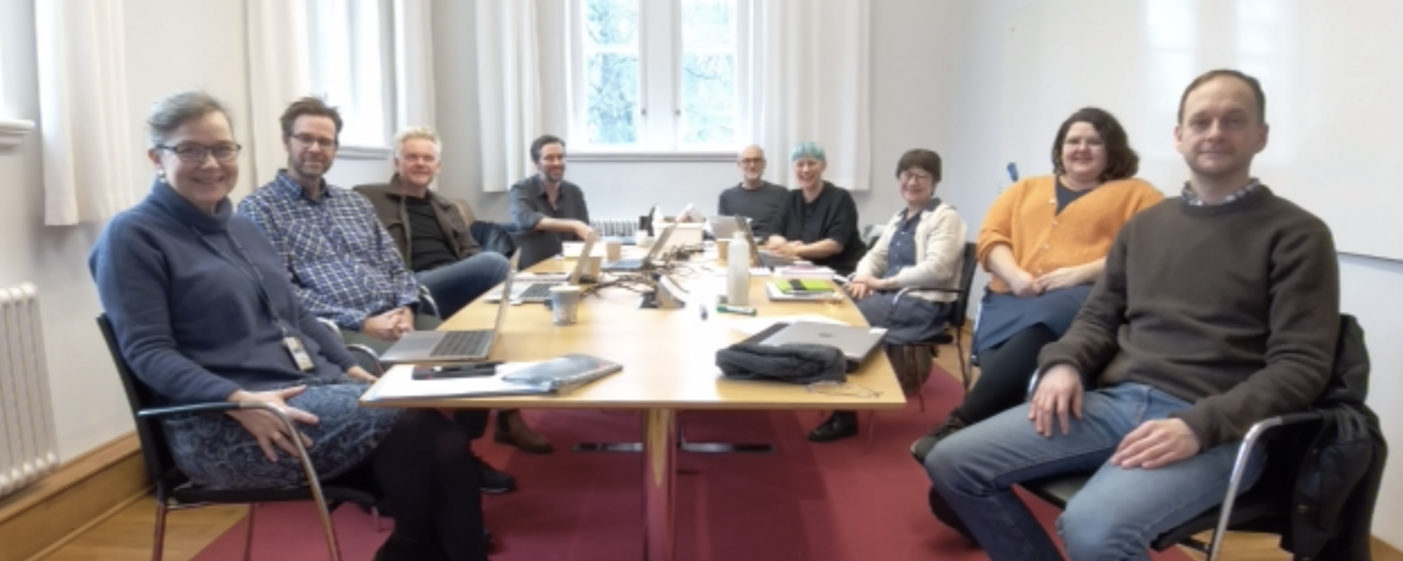 A blurry photo of nine people smiling at the camera.